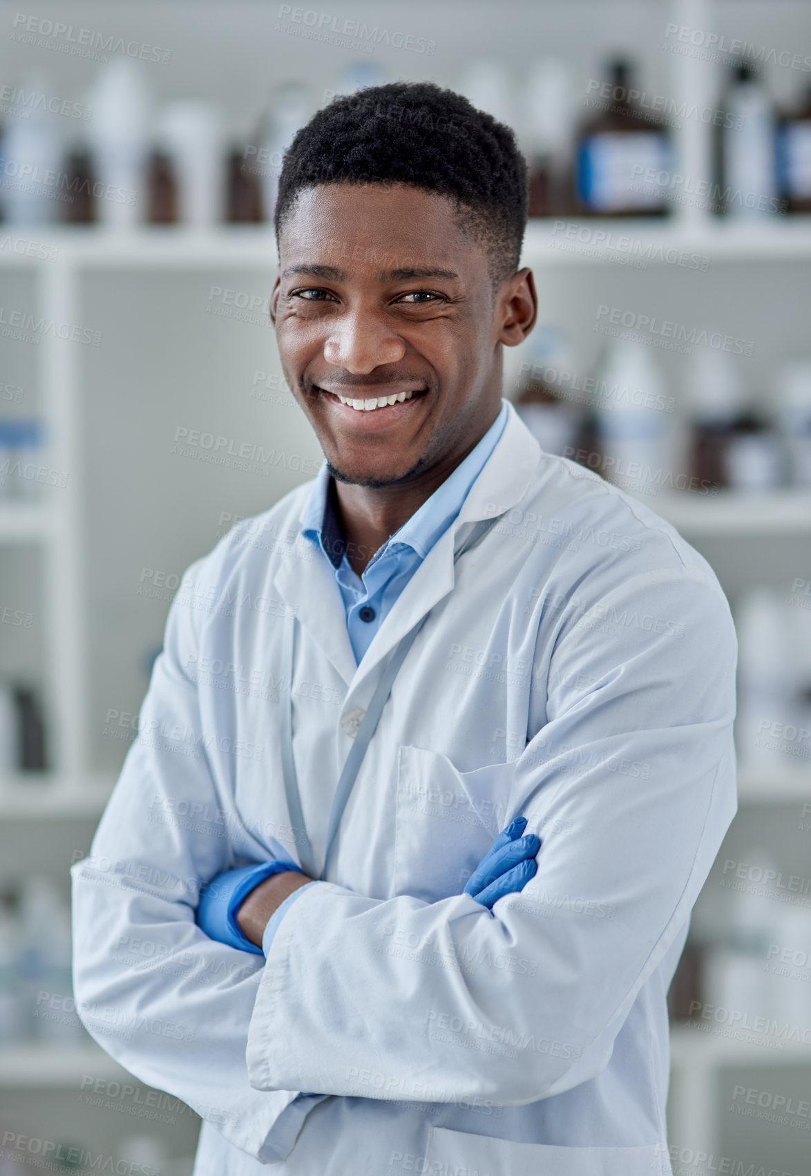 Buy stock photo Portrait of a cheerful young male scientist standing with arms folded inside of a laboratory