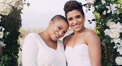Buy stock photo Cropped portrait of an affectionate young lesbian couple smiling while standing together on their wedding day