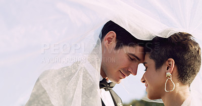 Buy stock photo Cropped shot of an affectionate young newlywed couple sharing an intimate moment while covering themselves with a veil on their wedding day