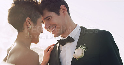 Buy stock photo Cropped shot of an affectionate young newlywed couple smiling at each other while covering themselves with a veil on their wedding day
