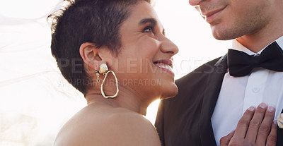 Buy stock photo Cropped shot of an affectionate young bride smiling at her groom while standing under a veil on their wedding day