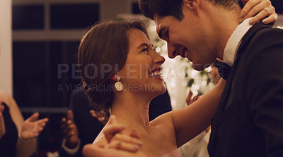 Buy stock photo Cropped shot of an affectionate young newlywed couple slow dancing with their guests in the background at their wedding reception