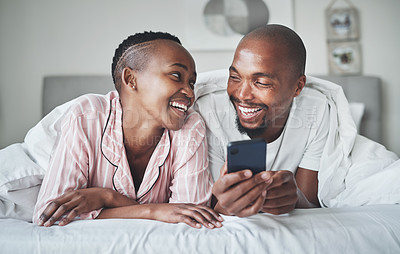 Buy stock photo Phone, social media and morning with a black couple in the bedroom together to relax on a bed in their home. Mobile, meme or contact with a man and woman browsing the internet, relaxing or bonding