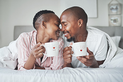 Buy stock photo Love, valentines day and black couple gift cups lying in bed in the morning drinking coffee in the bedroom together. Kiss, romantic and happy lovers relax in a home, house or apartment on holiday