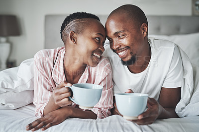 Buy stock photo Coffee, bedroom and morning with a black couple together on a bed in their home to relax on the weekend. Love, tea or early with a happy young man and woman relaxing while bonding in their house