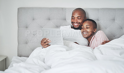 Buy stock photo Tablet, bedroom and a black couple streaming an online subscription service while in their bed together to relax. Social media, entertainment or video with a man and woman relaxing in the morning