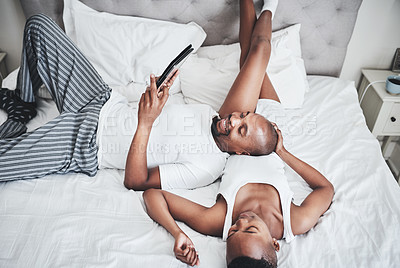 Buy stock photo Black couple, tablet and relaxing on bed with smile for entertainment, browsing or social media at home. Happy African American man and woman chilling in bedroom on touchscreen for morning streaming