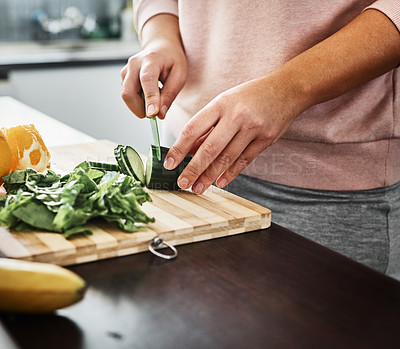 Buy stock photo Cropped shot of an unrecognizable woman chopping vegetables in the kitchen at home
