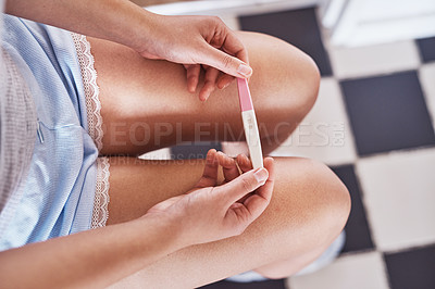 Buy stock photo Cropped shot of an unrecognizable woman taking a pregnancy test at home
