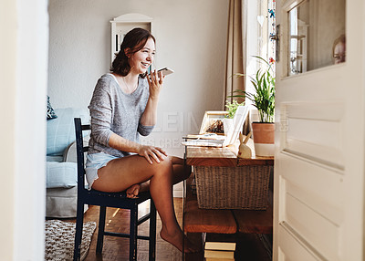Buy stock photo Shot of a beautiful young woman using her cellphone while sitting at home