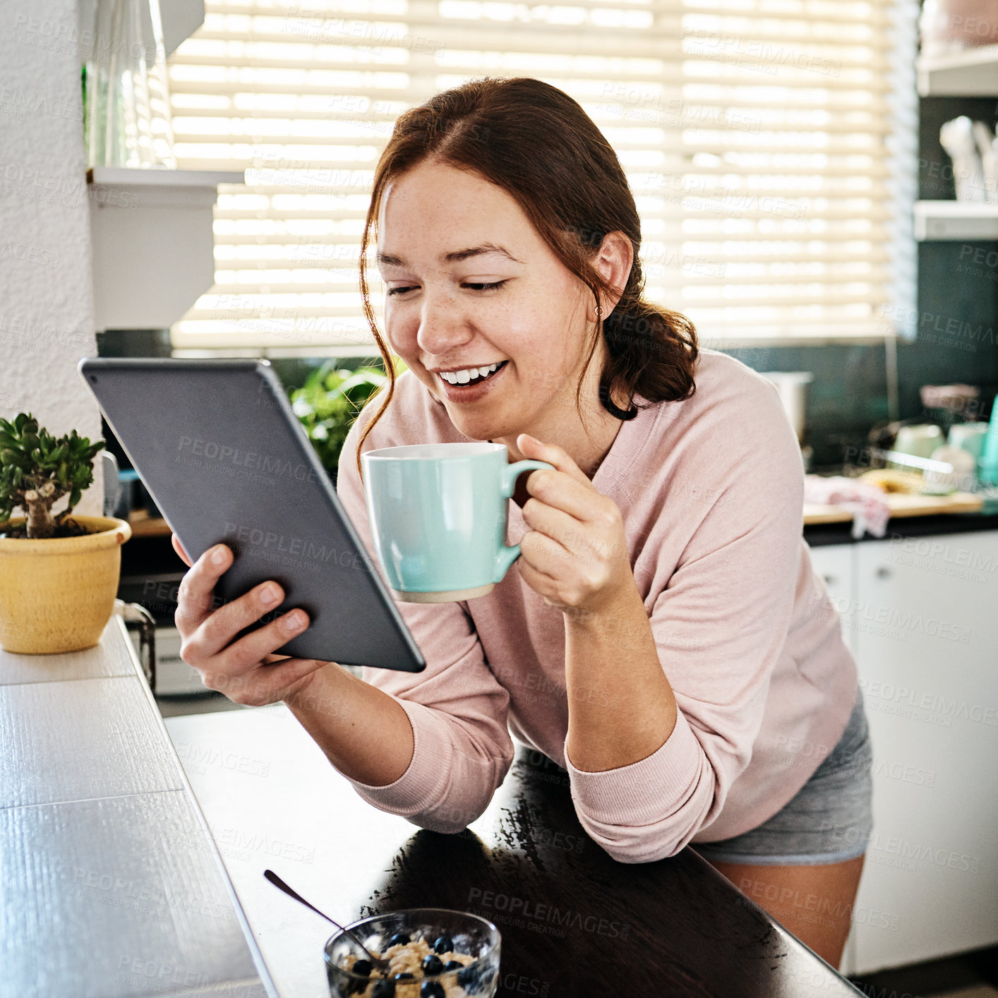 Buy stock photo Woman, coffee and tablet in kitchen, home and reading with smile, notification and email on app. Person, girl and tea cup with digital touchscreen at breakfast, morning and happy with social network