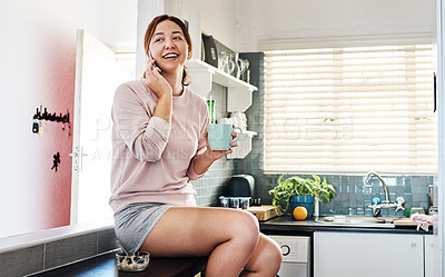 Buy stock photo Shot of a young woman talking on the phone while sitting at home