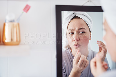 Buy stock photo Cropped shot of a beautiful young woman analyzing her skin in the bathroom mirror