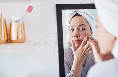 Buy stock photo Cropped shot of a beautiful young woman analyzing her skin in the bathroom mirror