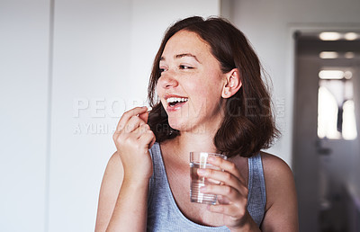 Buy stock photo Healthcare, medication and woman drinking a pill with a glass water for wellness at her home. Medicine, medical and happy female person taking a vitamin, supplement or tablet with liquid in apartment