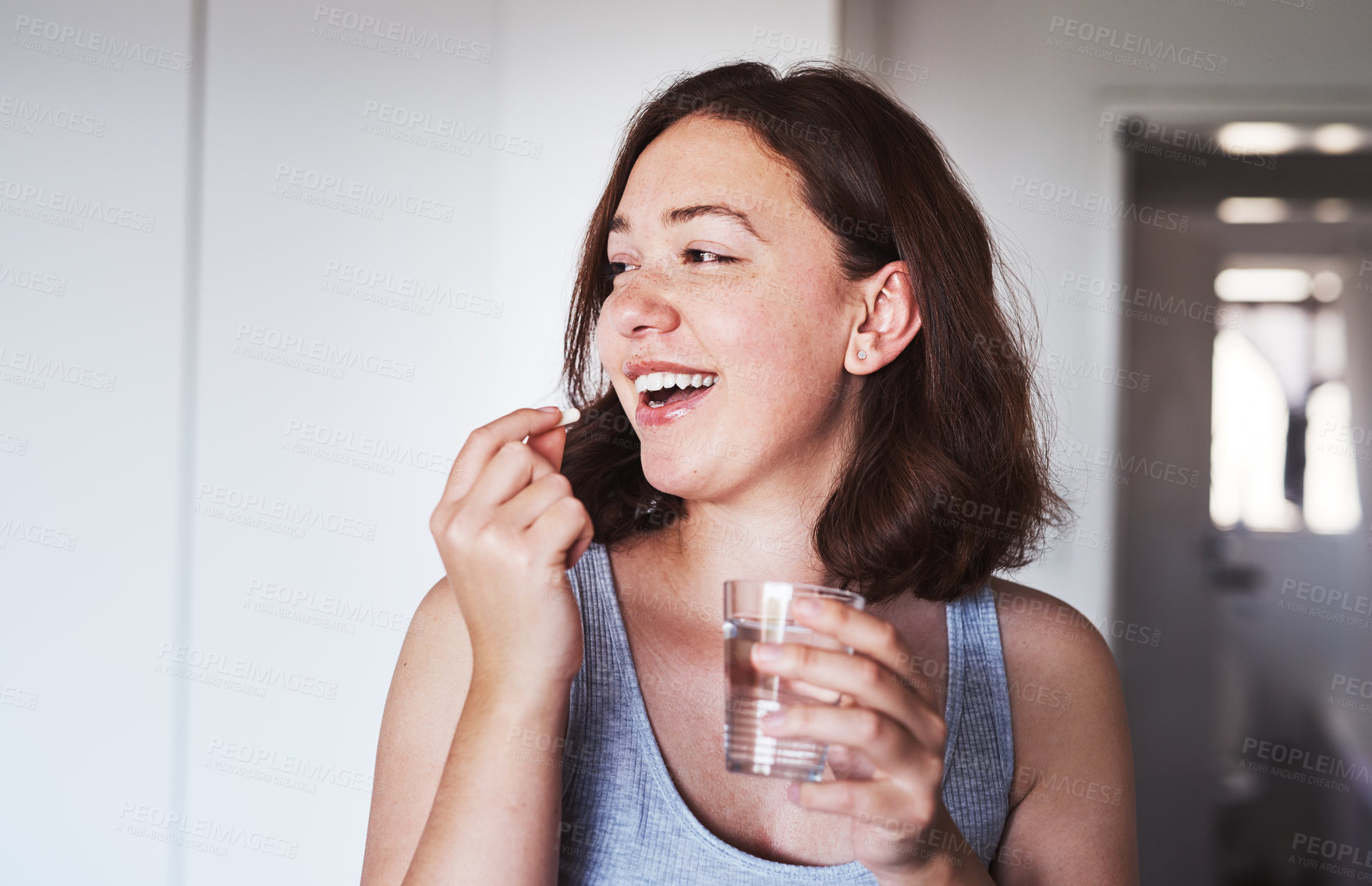 Buy stock photo Healthcare, medication and woman drinking a pill with a glass water for wellness at her home. Medicine, medical and happy female person taking a vitamin, supplement or tablet with liquid in apartment