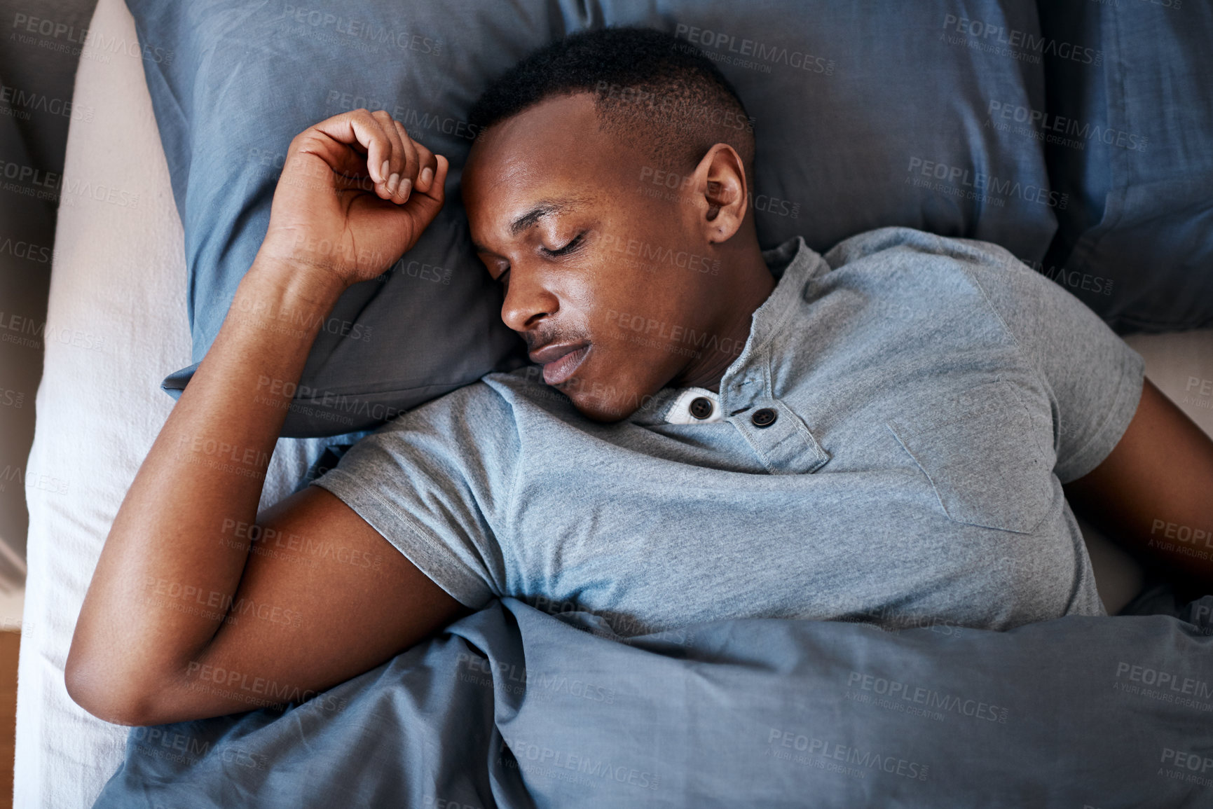 Buy stock photo Cropped shot of a handsome young man sleeping in his bed during a day off at home alone