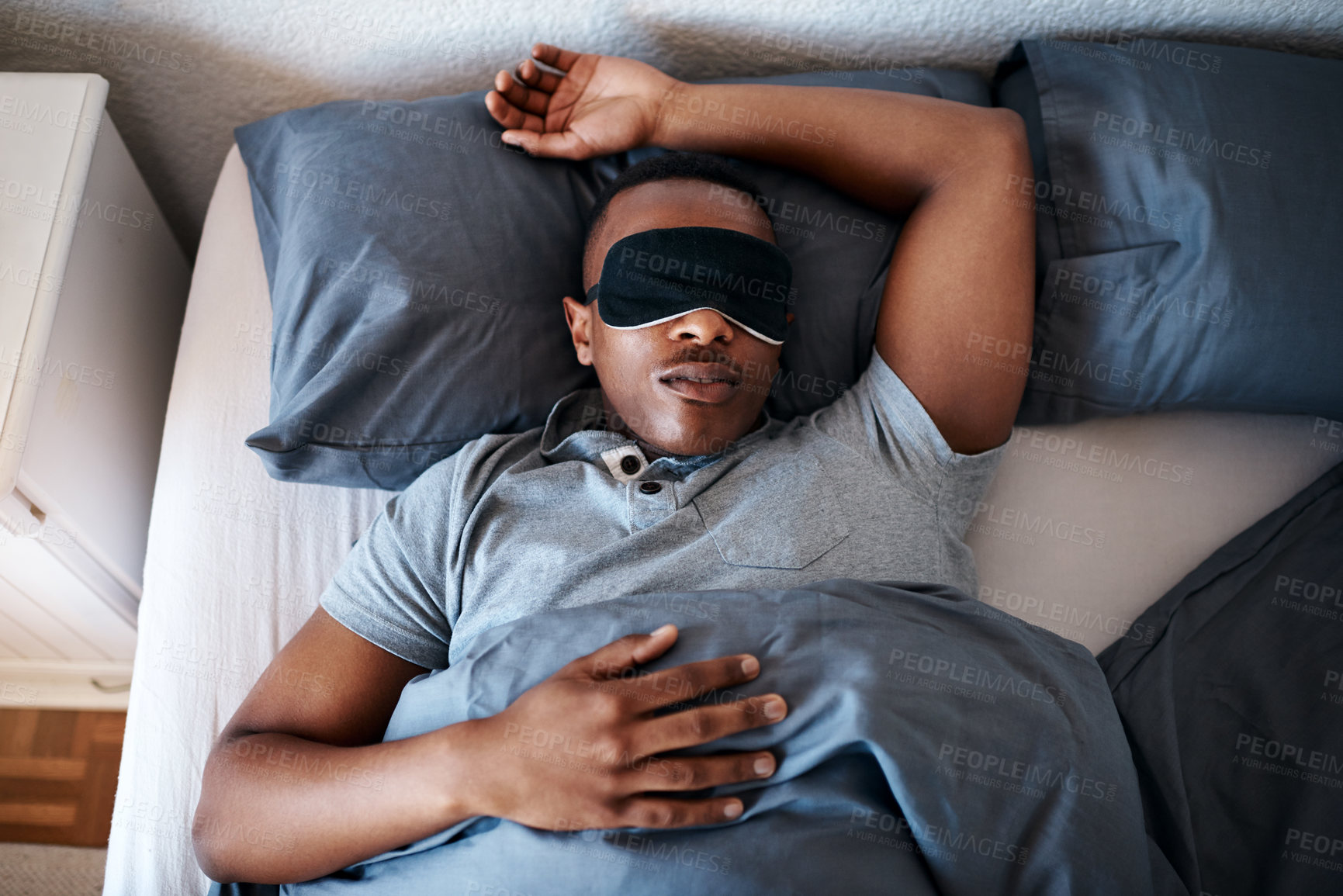 Buy stock photo Bed, sleep and black man in home with mask on eyes, peace and calm weekend morning with tired head on pillow. Relax, rest and exhausted person in bedroom with dream, fatigue and comfort in apartment