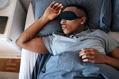 Buy stock photo Cropped shot of a handsome young man wearing a night mask and sleeping in his bed at home