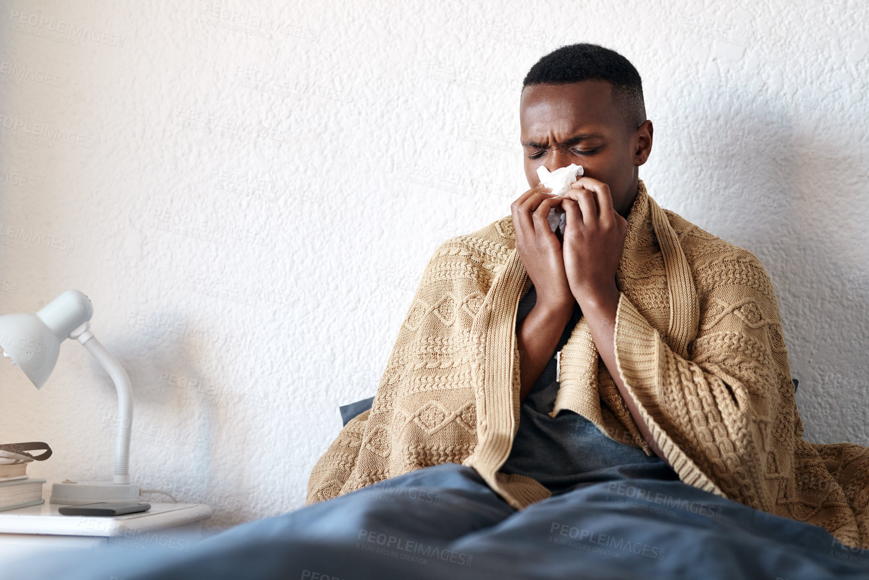 Buy stock photo Blowing nose, man and sick with allergies in home, sneezing and bacteria infection in bedroom. Apartment, male person and sinus with tissue for flu virus, fever and disease on weekend in bed