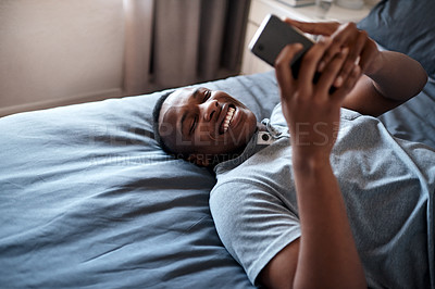 Buy stock photo Happy, laugh and black man on bed with phone for social media, online chatting and internet in bedroom. Relax, rest and person on smartphone for website, networking and message on weekend in home