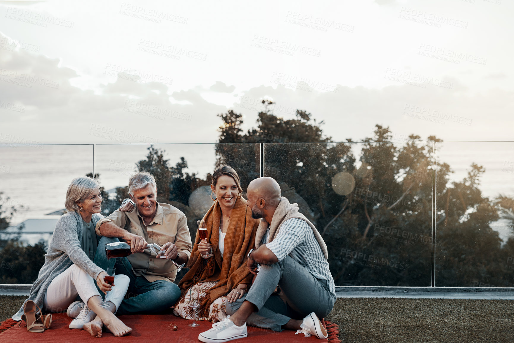 Buy stock photo Full length shot of an affectionate family having wine together while celebrating a new year outdoors