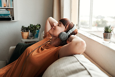 Buy stock photo Relax, headphones and woman listening to music, podcast or radio while resting on a sofa. Calm, chill and female person streaming album, playlist or song while sleeping in the living room of her home