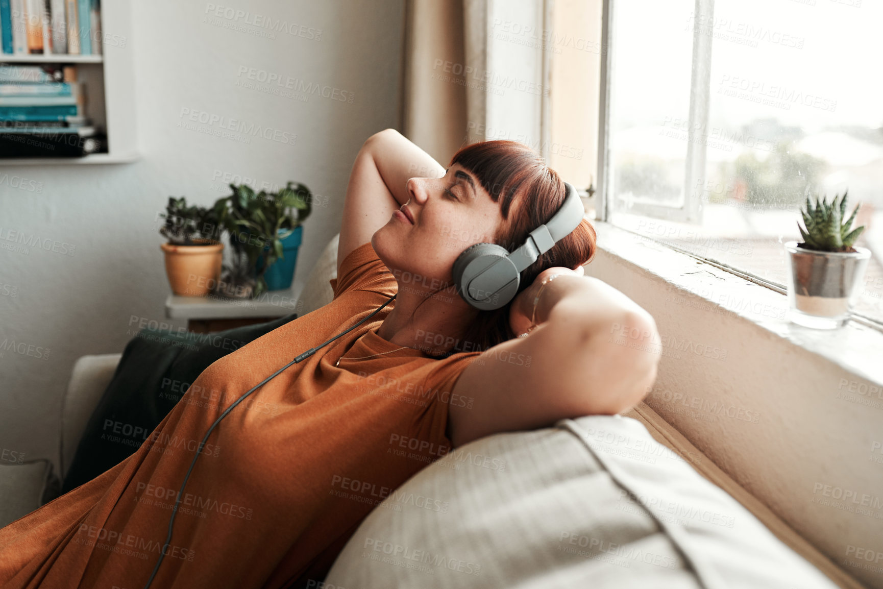Buy stock photo Relax, headphones and woman listening to music, podcast or radio while resting on a sofa. Calm, chill and female person streaming album, playlist or song while sleeping in the living room of her home