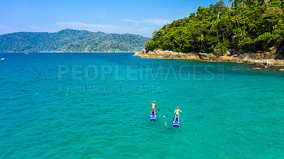 Buy stock photo Paddle board, travel and couple in ocean on holiday, vacation and explore on tropical island together. Honeymoon activity, hobby and man and woman for adventure, journey and water sports in nature