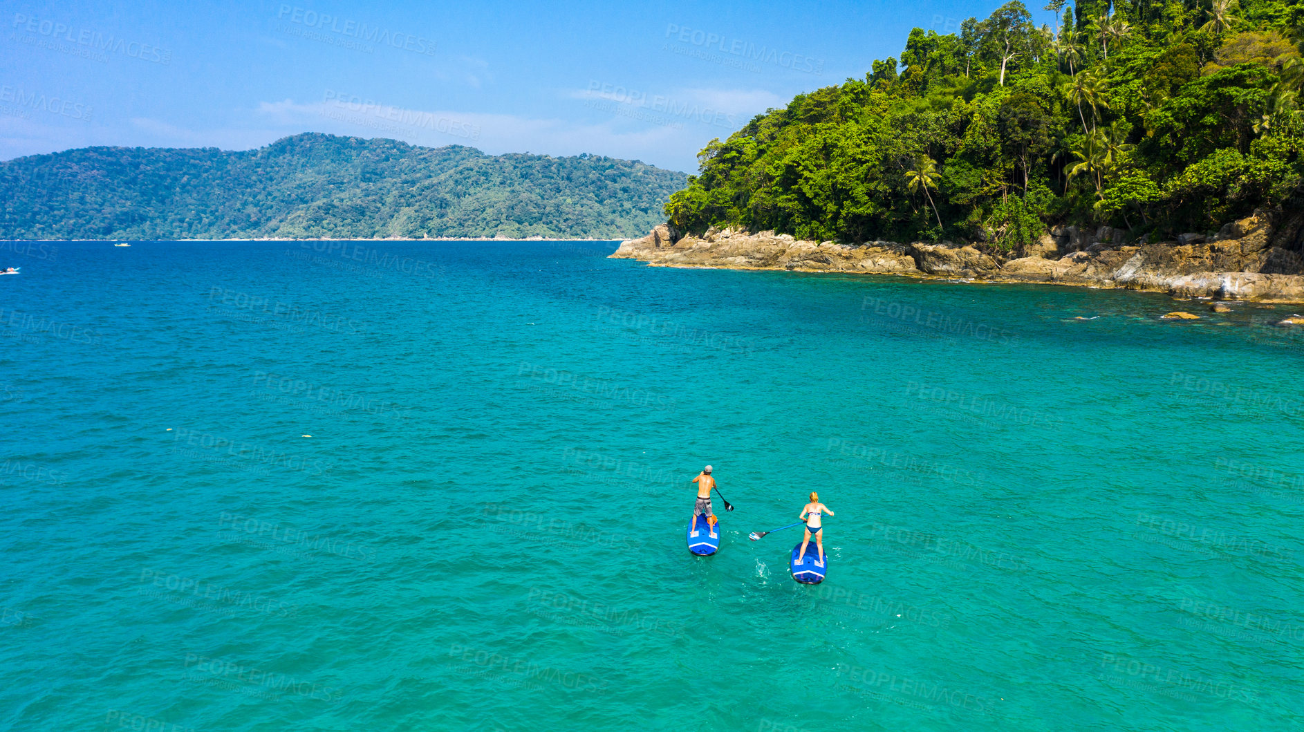 Buy stock photo Paddle board, travel and couple in ocean on holiday, vacation and explore on tropical island together. Honeymoon activity, hobby and man and woman for adventure, journey and water sports in nature