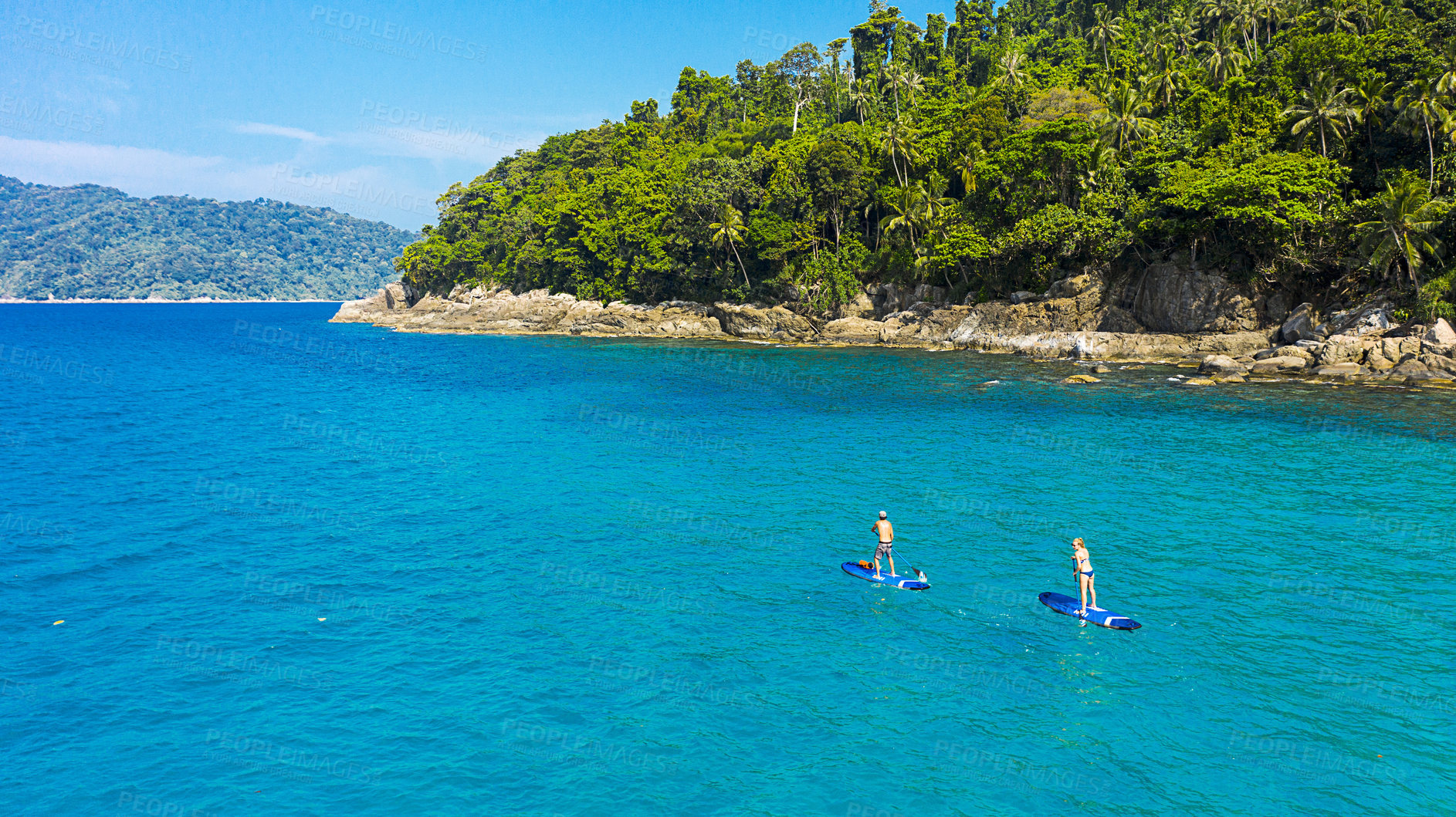 Buy stock photo Paddle board, travel and couple in blue ocean on holiday, vacation and explore on tropical island together. Honeymoon, hobby and man and woman for adventure, journey and water sports in nature