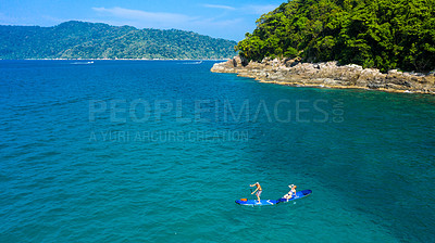 Buy stock photo Couple, paddle board and ocean in summer, vacation and adventure on holiday, island and outdoor in sunshine. People, man and woman at sea with tropical water, journey and above in nature in Malaysia