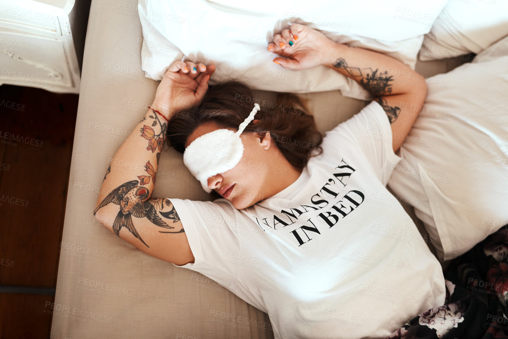 Buy stock photo Cropped shot of a young woman wearing a sleeping mask while sleeping in her bed at home