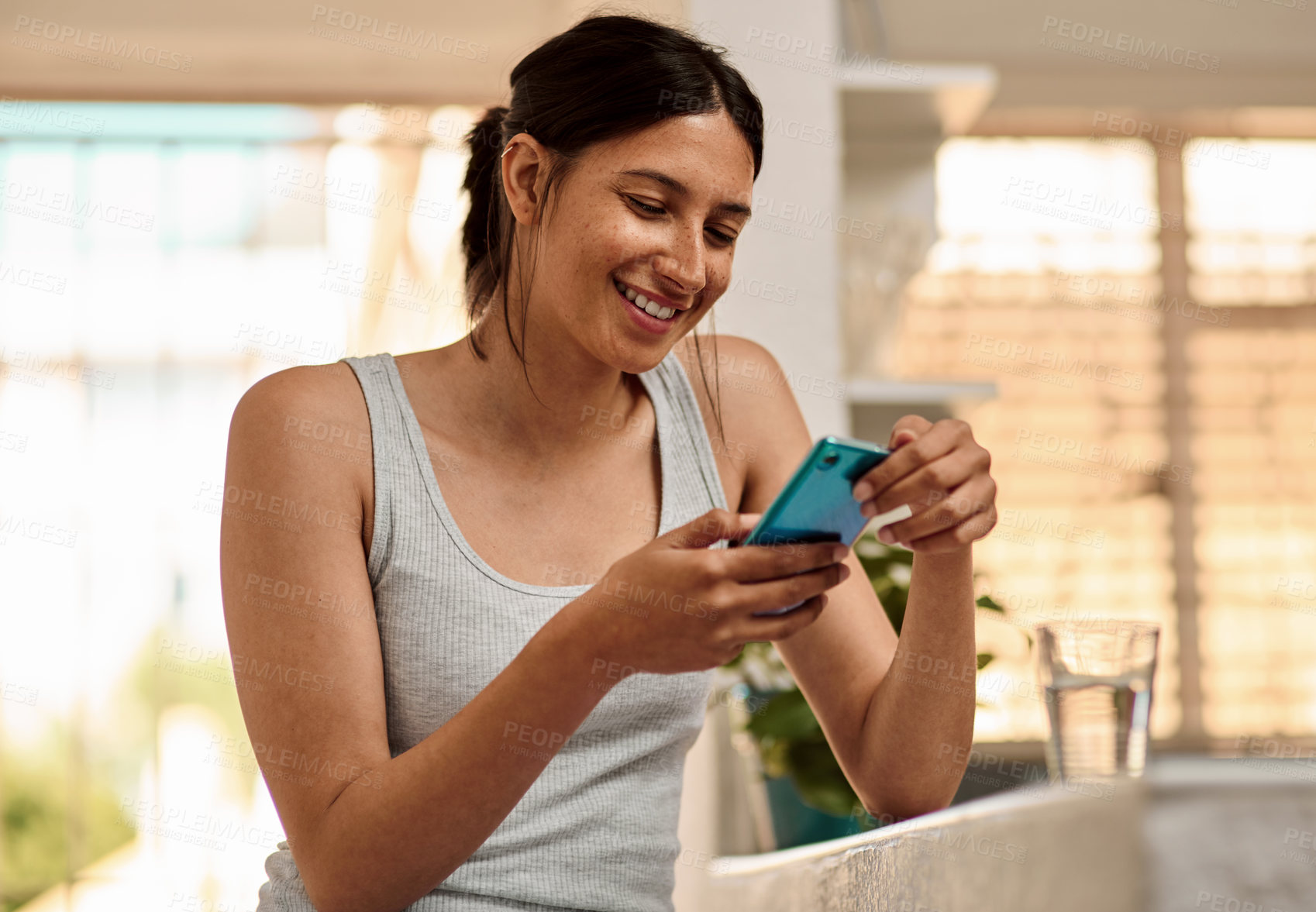 Buy stock photo Shot of a young woman using a smartphone in the morning at home