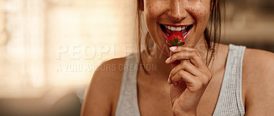Buy stock photo Cropped shot of a young woman eating a strawberry at home