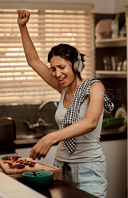 Buy stock photo Music headphones, singing and woman cooking with strawberry. Sing, kitchen and female person making snack with fruit for healthy nutrition while dancing to audio, sound and radio podcast in home.