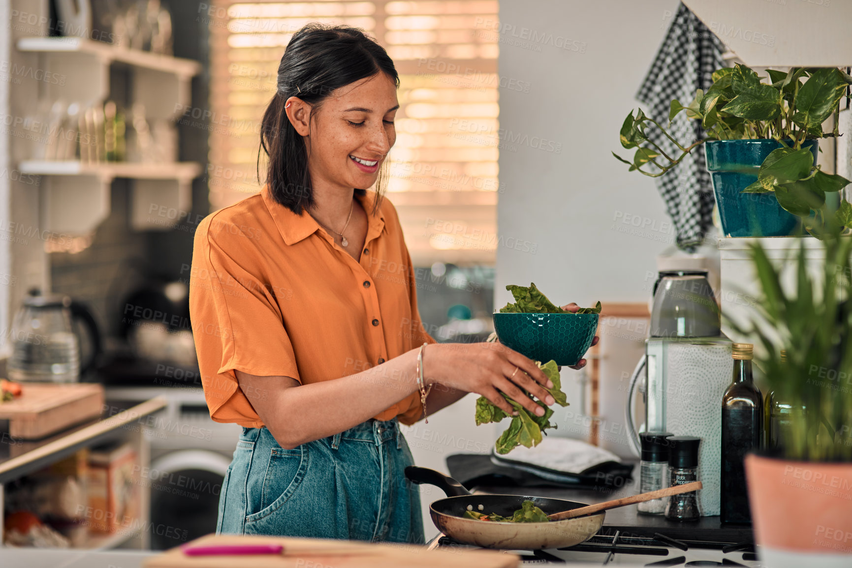 Buy stock photo Shot of a happy young woman preparing a healthy meal at home