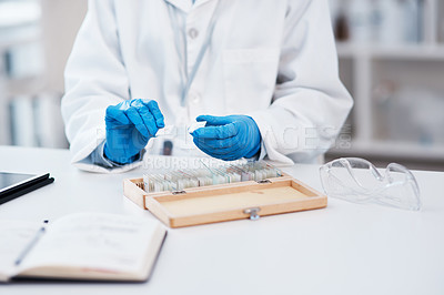 Buy stock photo Closeup shot of an unrecognisable scientist working with microscope slides from a box in a lab