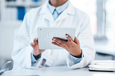 Buy stock photo Closeup shot of an unrecognisable scientist using a digital tablet in a lab