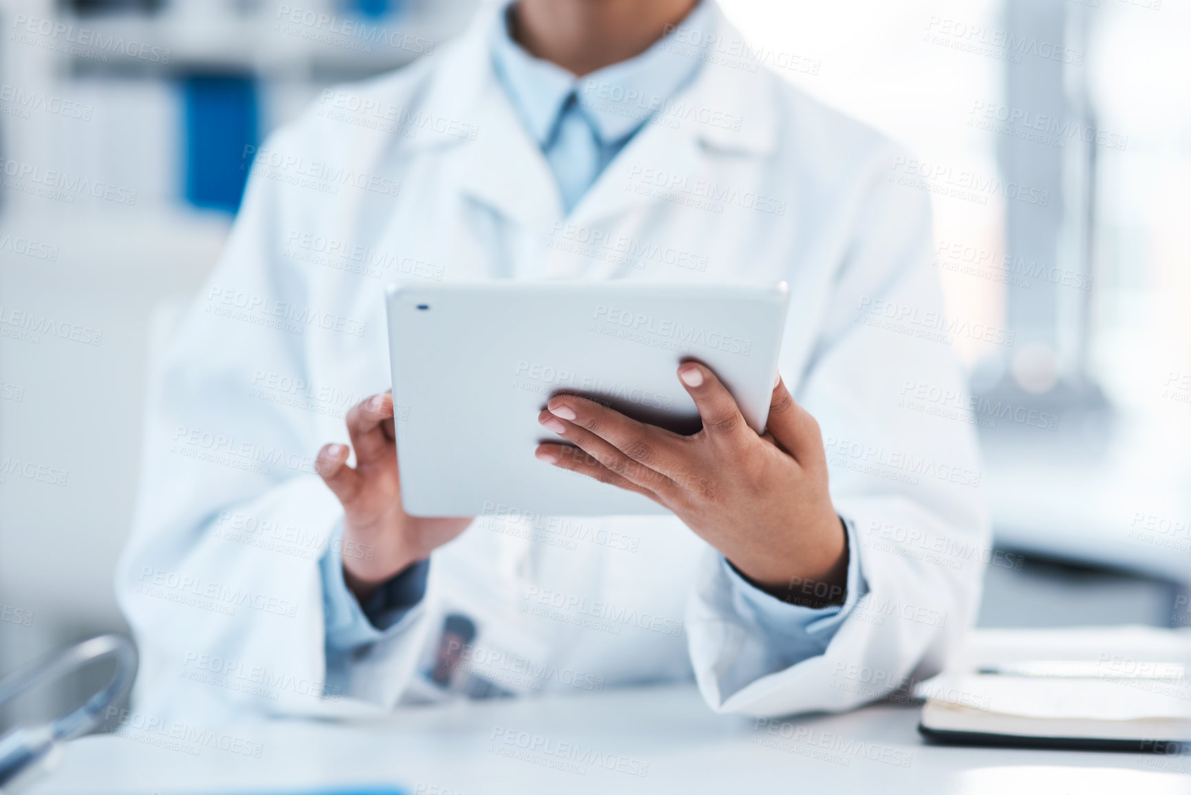 Buy stock photo Closeup shot of an unrecognisable scientist using a digital tablet in a lab