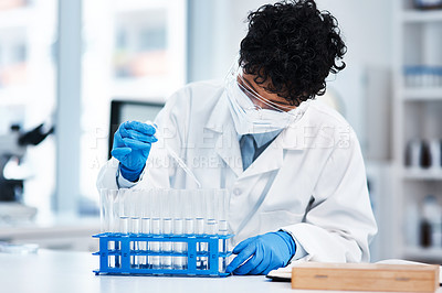 Buy stock photo Shot of a young scientist using a dropper while working with samples in a lab