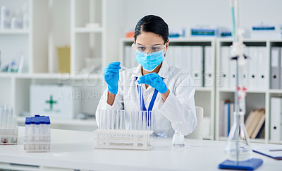 Buy stock photo Shot of a young scientist conducting an experiment in a laboratory