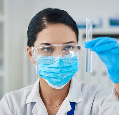 Buy stock photo Shot of a young scientist conducting an experiment in a laboratory