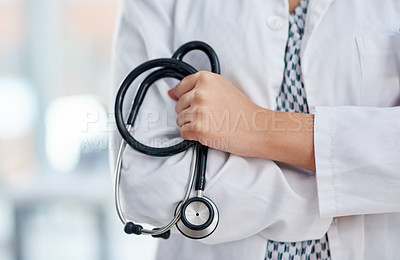 Buy stock photo Cropped shot of an unrecognisable doctor holding a stethoscope and crossing her arms
