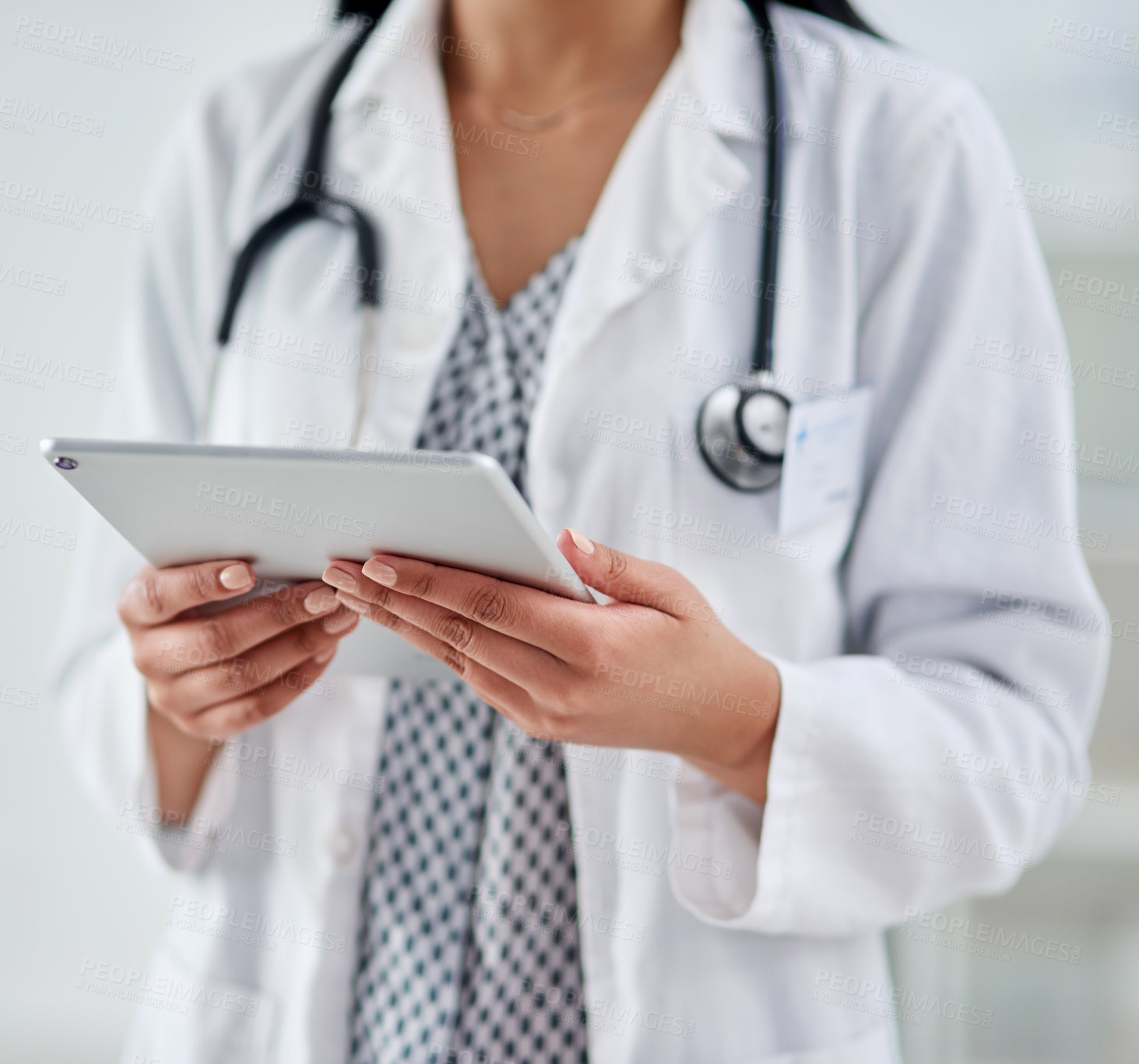 Buy stock photo Cropped shot of an unrecognizable doctor using a digital tablet while working in a clinic