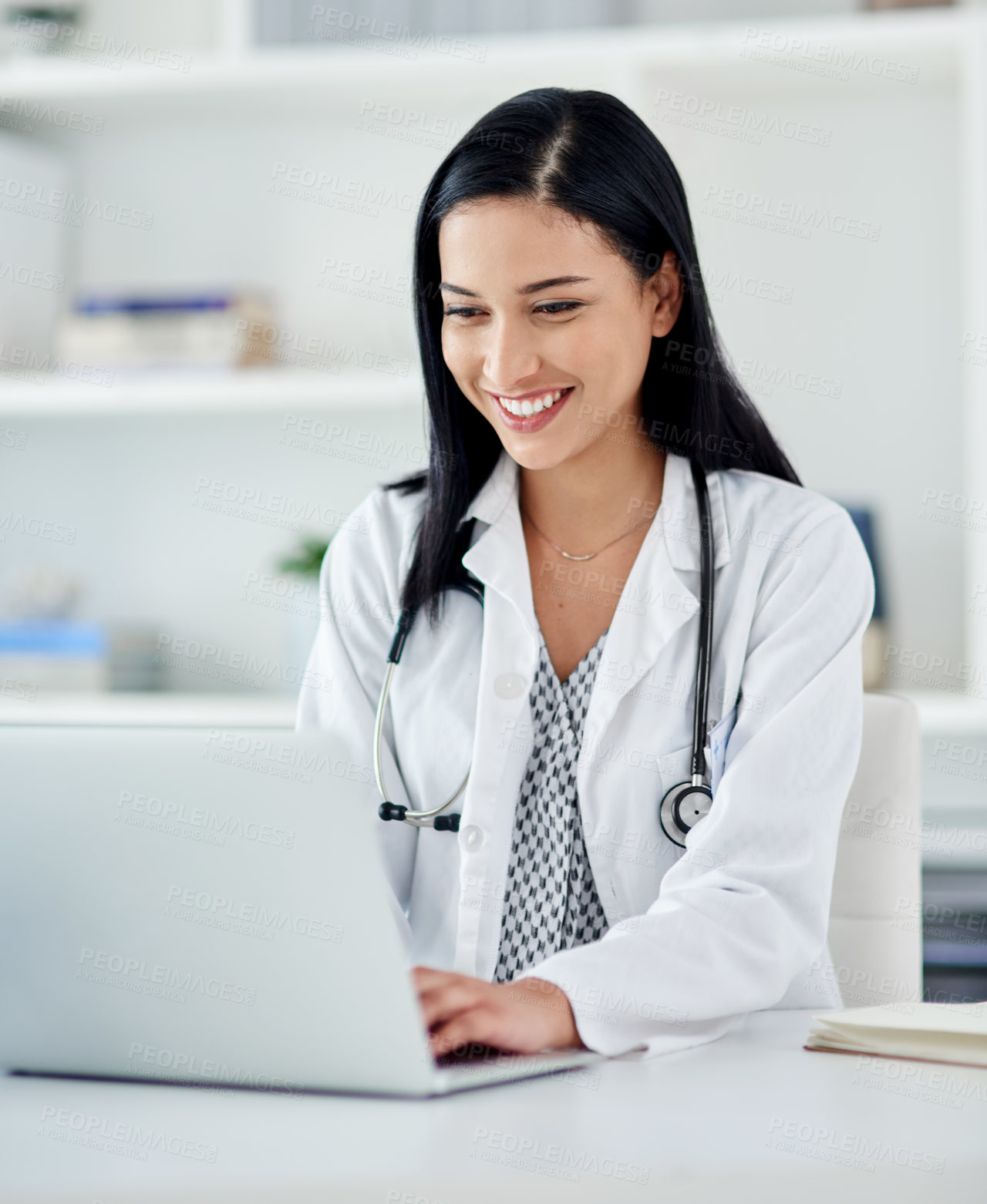 Buy stock photo Shot of a young doctor using a laptop at her desk