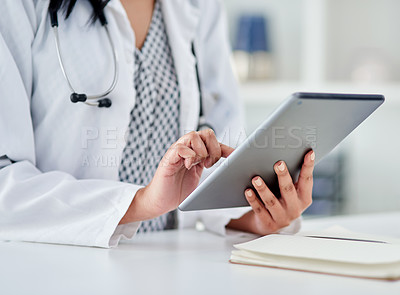 Buy stock photo Cropped shot of an unrecognizable doctor using a digital tablet while working in a clinic