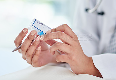 Buy stock photo Cropped shot of a doctor filling out a prescription in her consulting room