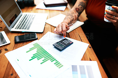 Buy stock photo Cropped shot of an unrecognizable businesswoman sitting and using a calculator to calculate her finances