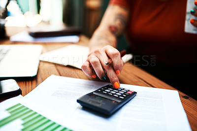 Buy stock photo Cropped shot of an unrecognizable businesswoman sitting and using a calculator to calculate her finances